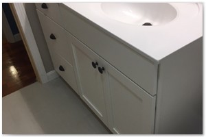 FAMILY BATHROOM RENOVATION - We installed a new four-foot white vanity with a white Corian countertop. We finished the bathroom off with rub bronze fixtures and hardware, long gray porcelain gray tiles on the floor and a 6-panel pine pocket door.
